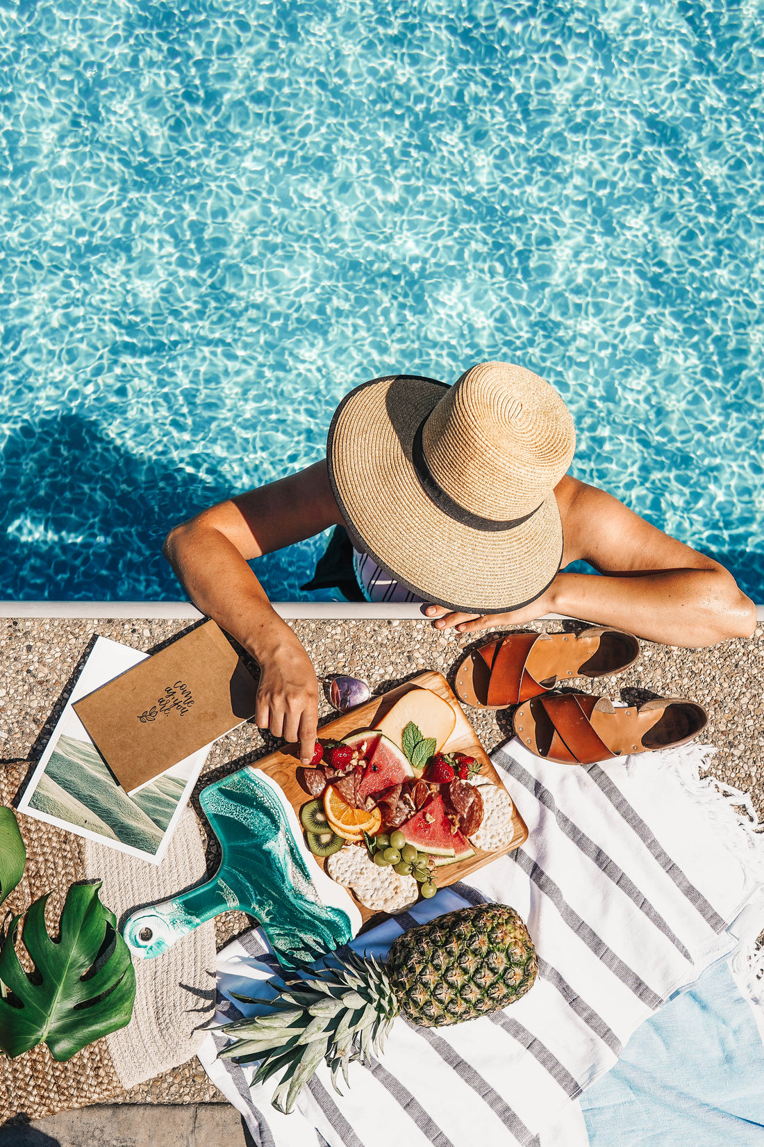 cheese board being enjoyed beside a pool outside
