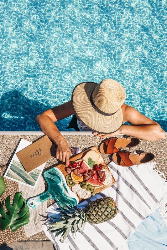 cheese board being enjoyed beside a pool outside