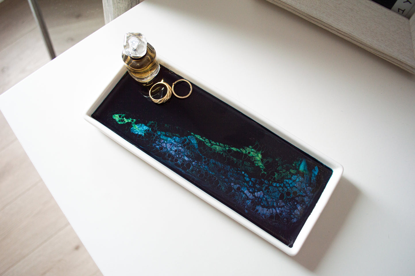 northern lights small ceramic tray with jewelry and perfume on it