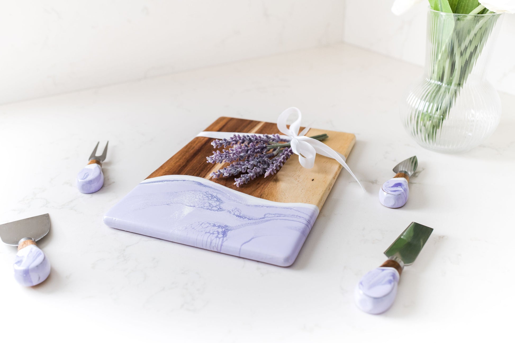 lavender date night board with matching cheese knives sitting on a kitchen counter