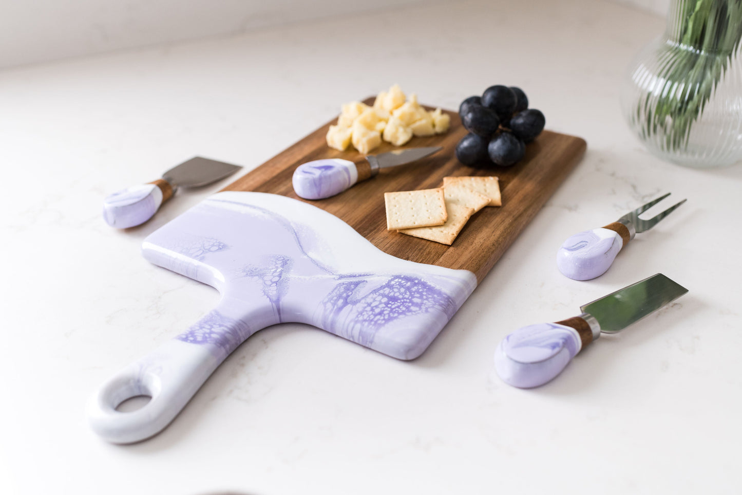Medium lavender board with matching cheese knives sitting on a kitchen counter