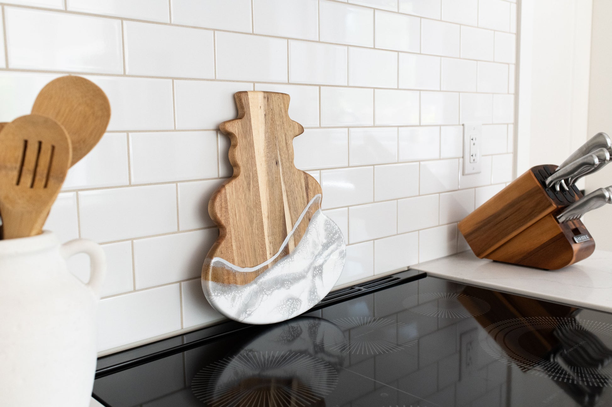 silver metallic snowman board against a white backsplash 