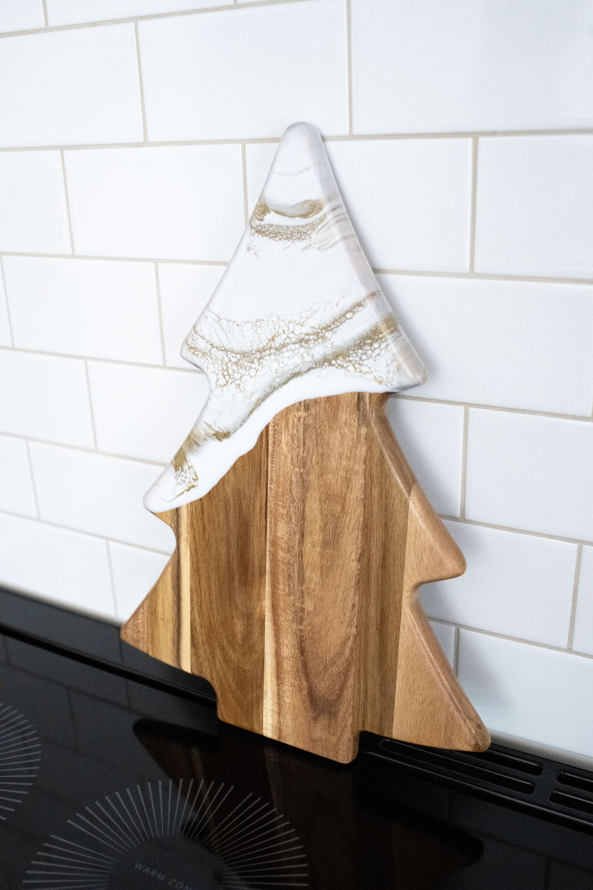 Gold Quartz Christmas tree shaped board against a white back splash 
