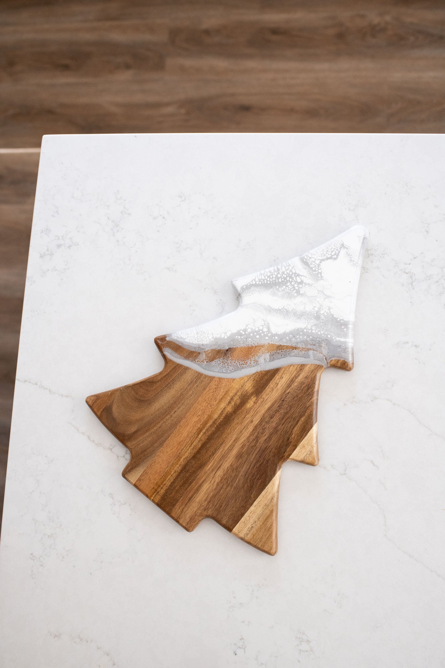Christmas tree shaped board a with a silver white resin design on it 