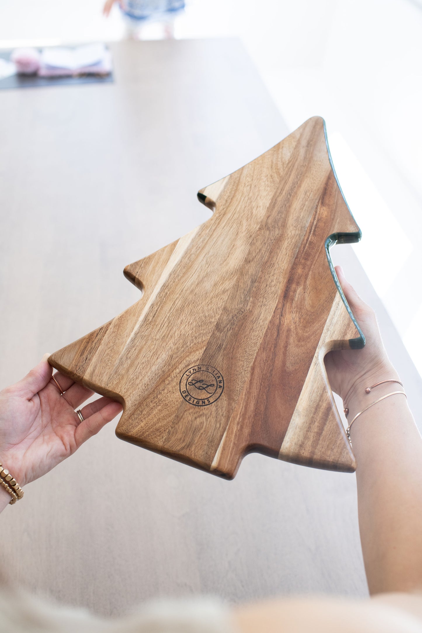 hands holding the Christmas tree board turn around to show the wooden background 