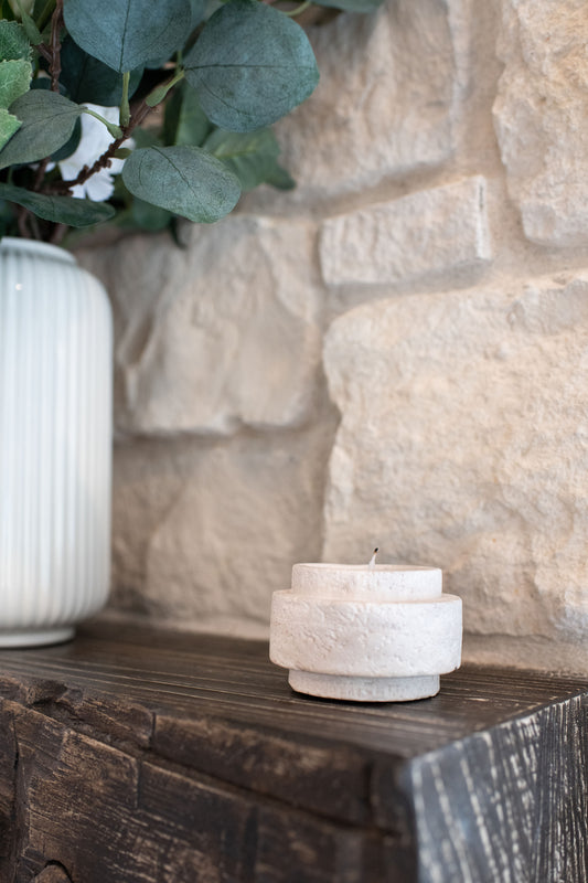 Limestone candle holder on a wooden mantel 