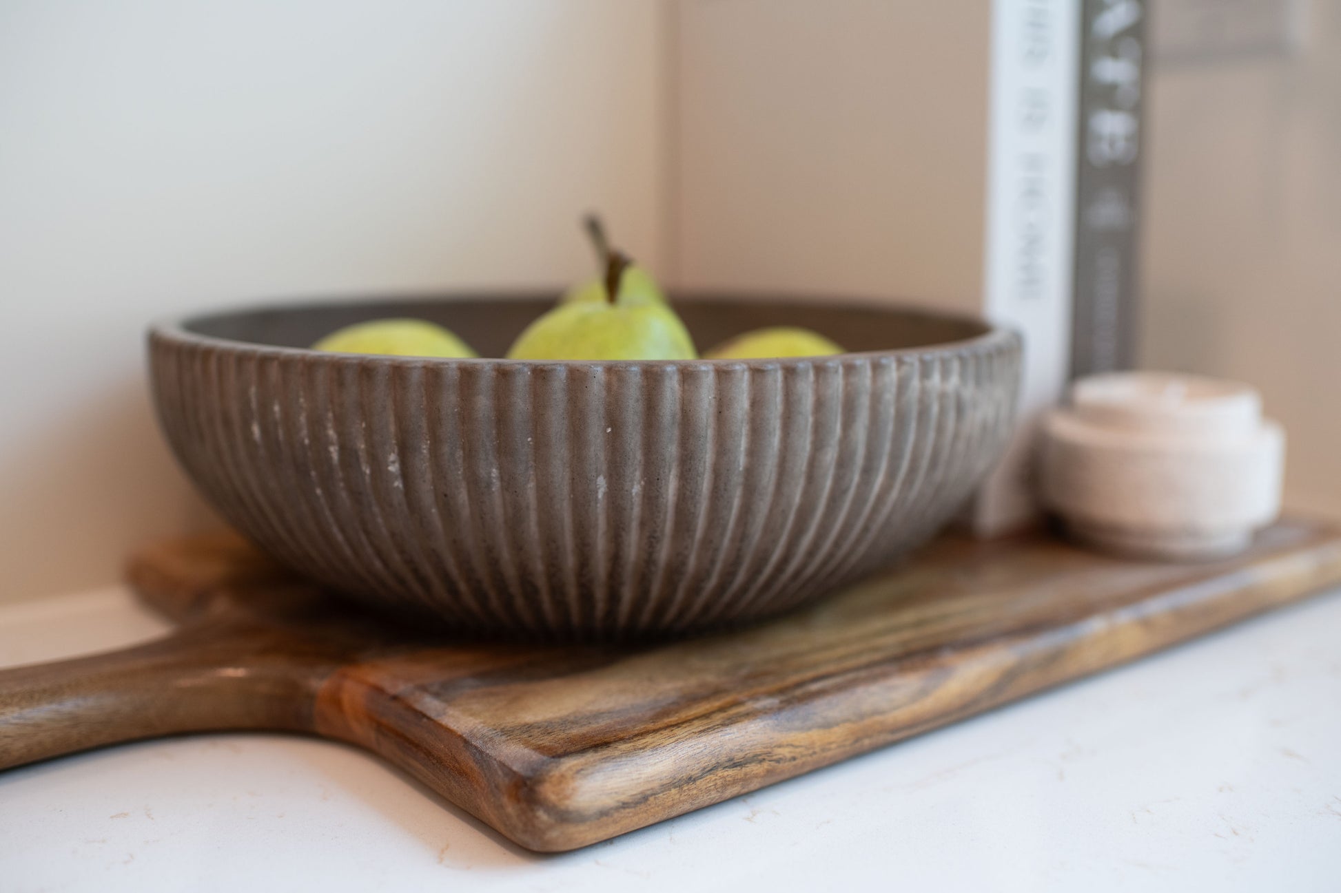 Mocha stone  bowl with pears on a wooden cutting board