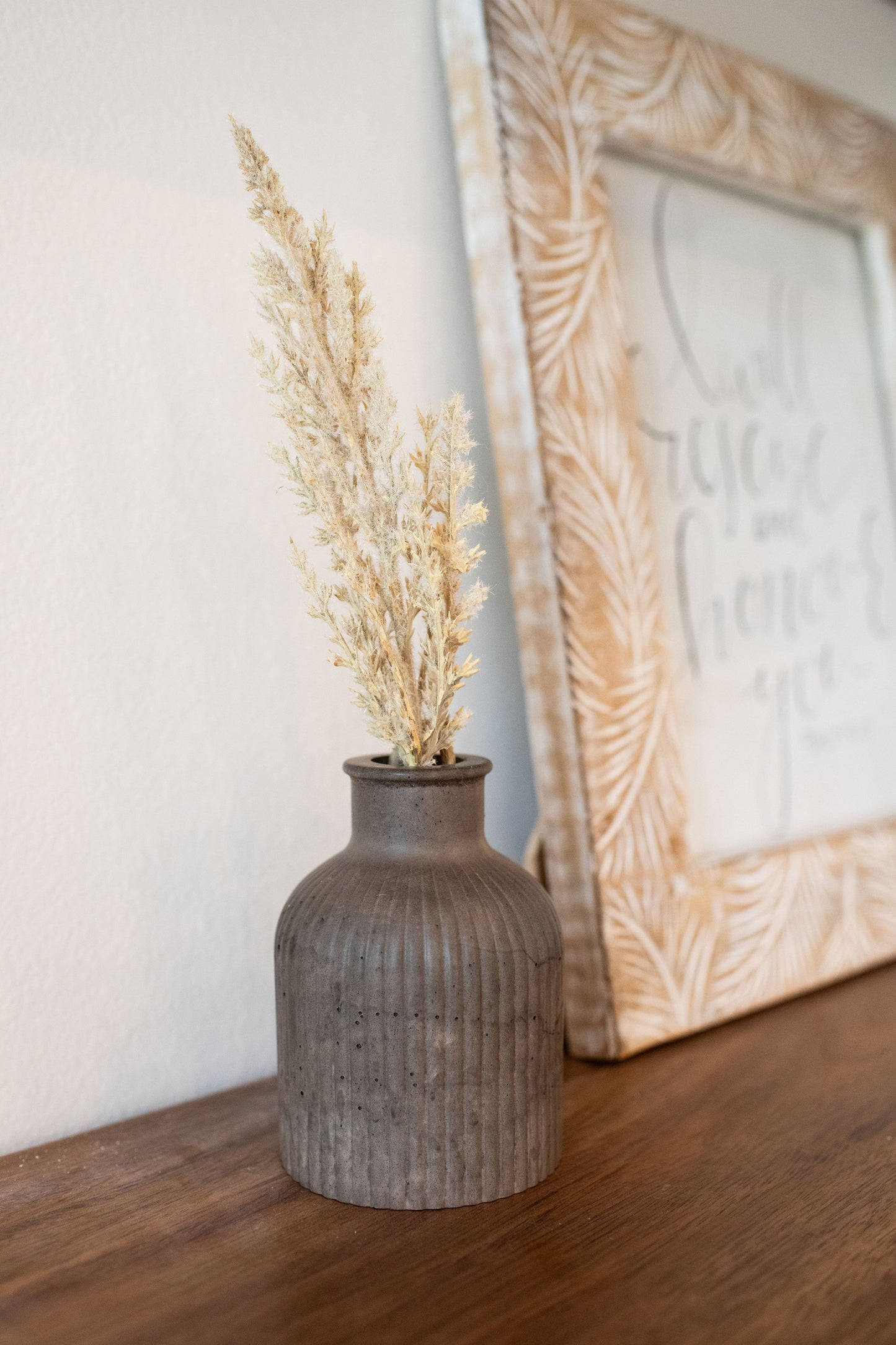 Mocha stone budvase with a dried up plant for decor 