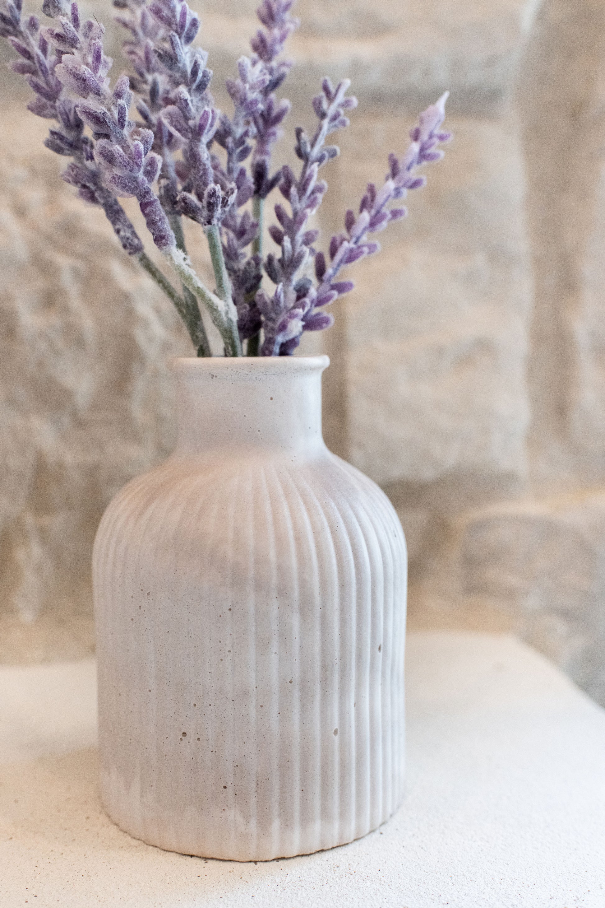 Limestone budvase with a lavender plant in it 