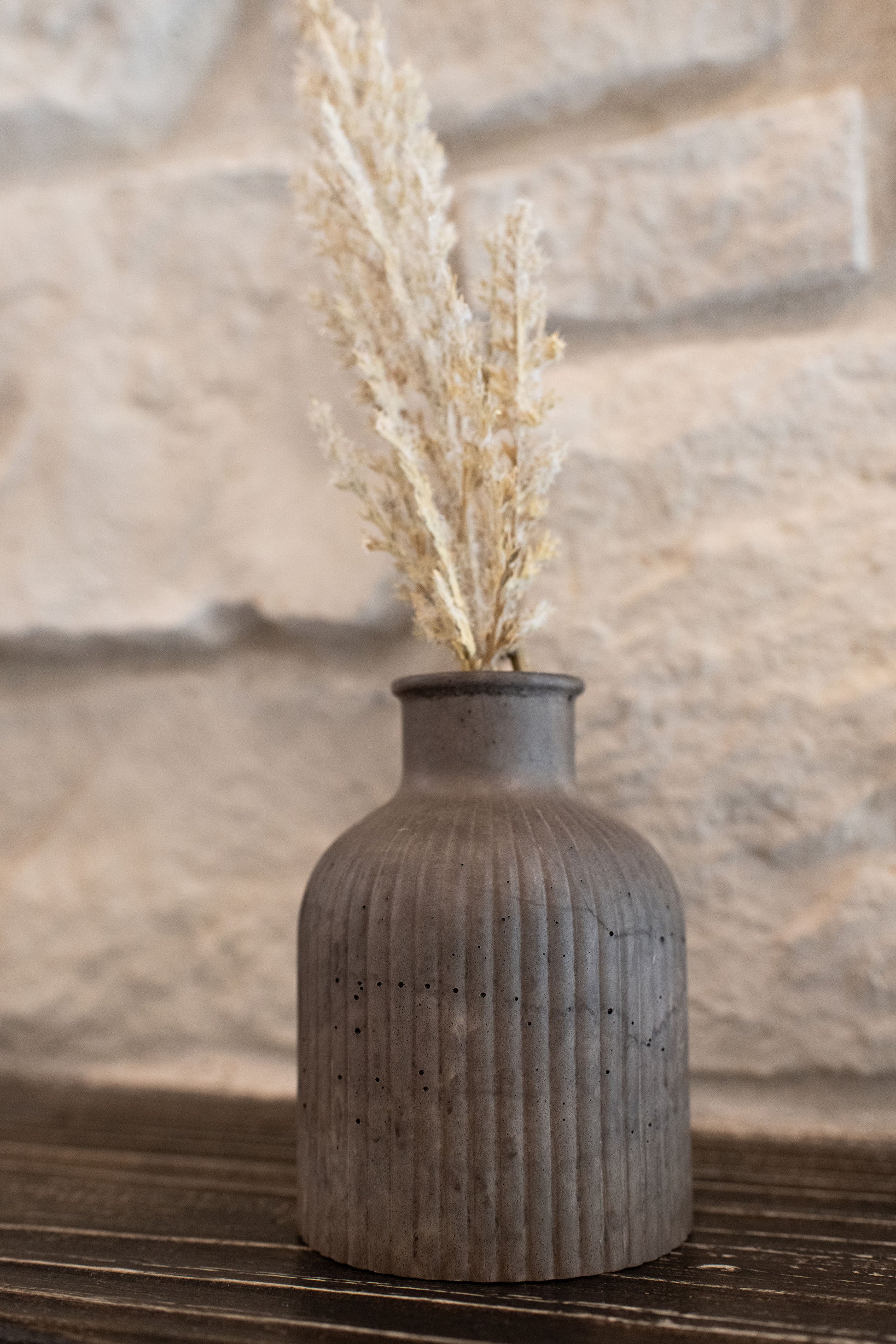 Mocha budvase on a wooden ledge and stone background 