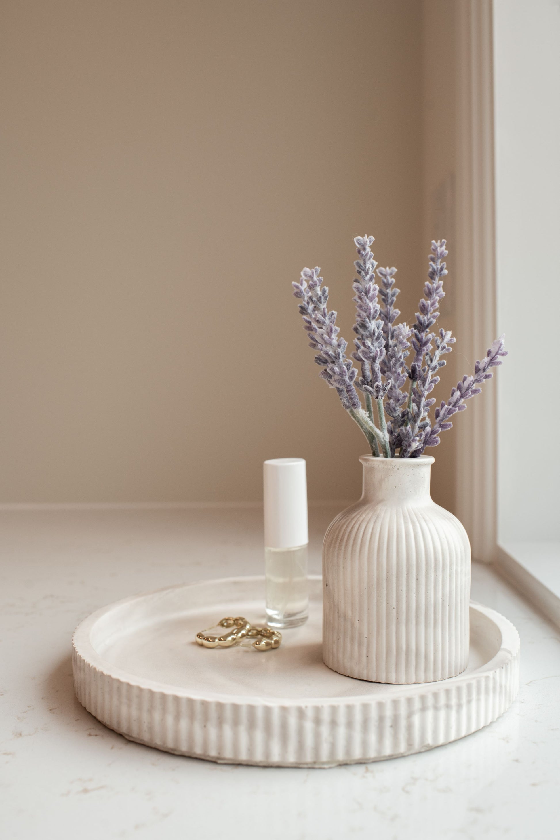 limestone budvase with lavender on our round limestone tray against a neutral wall.