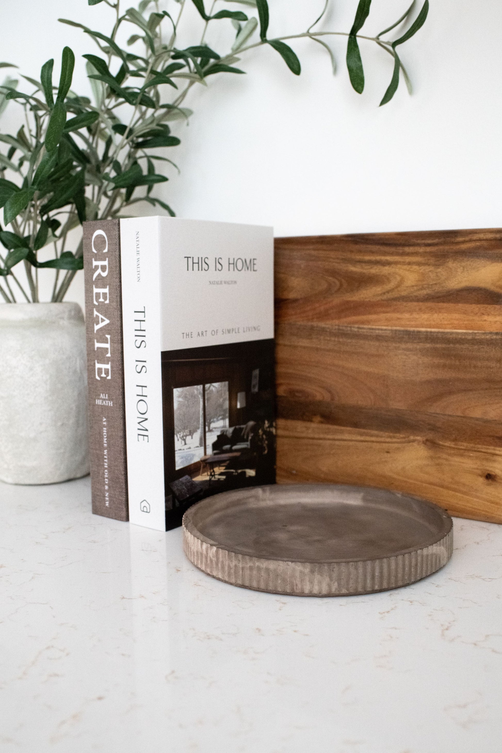 kitchen decorated with books, olive branch, wooden cutting board an our mocha round tray 