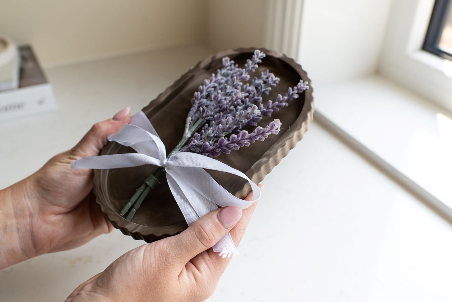 Mocha stone oval tray with a white bow and lavender stem 