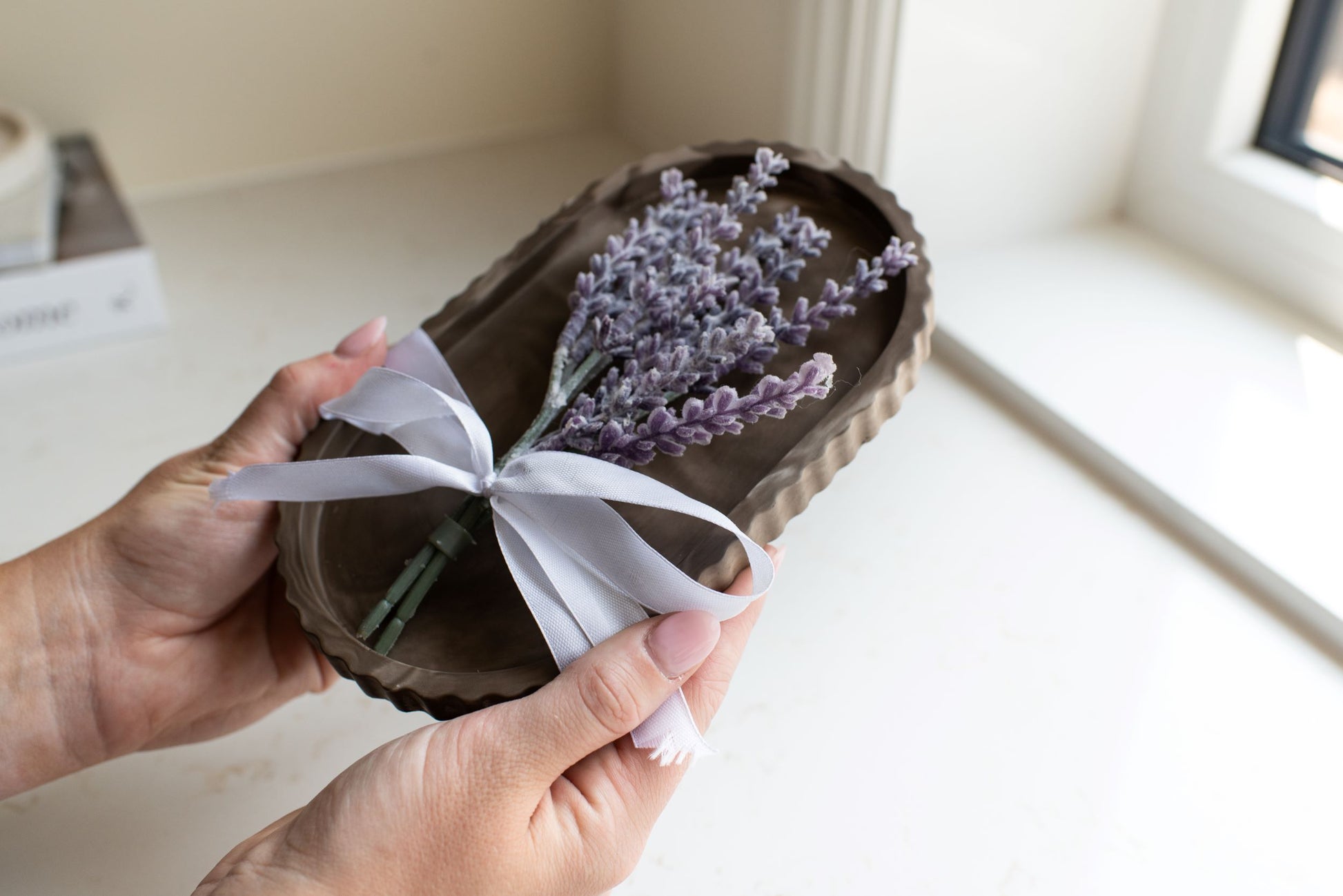 Mocha stone oval tray with a white bow and lavender stem 