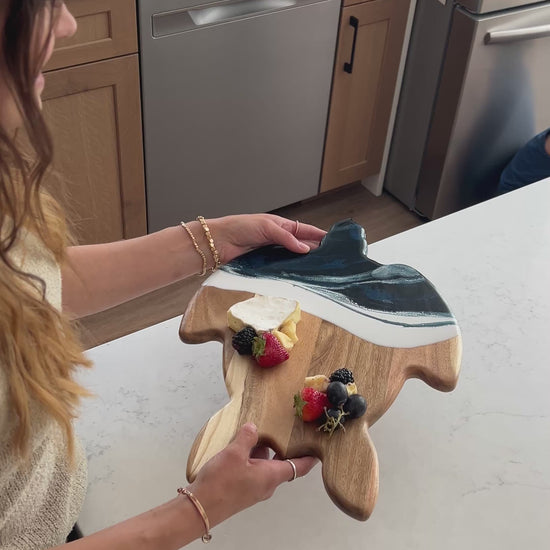 video of a women holding the navy white turtle board 