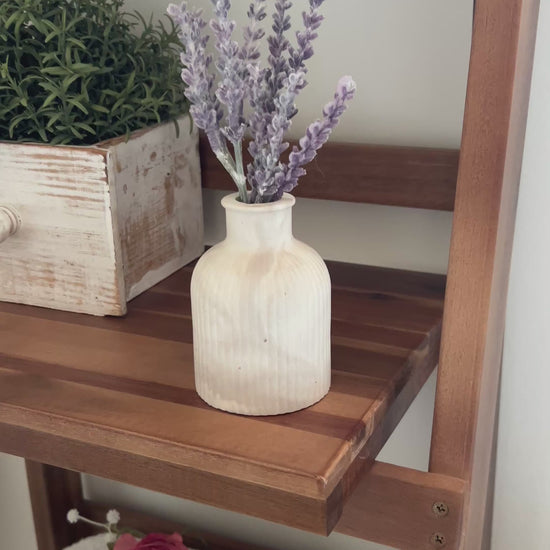Video showing the Limestone budvase on a wooden shelf in a bathroom setting. 