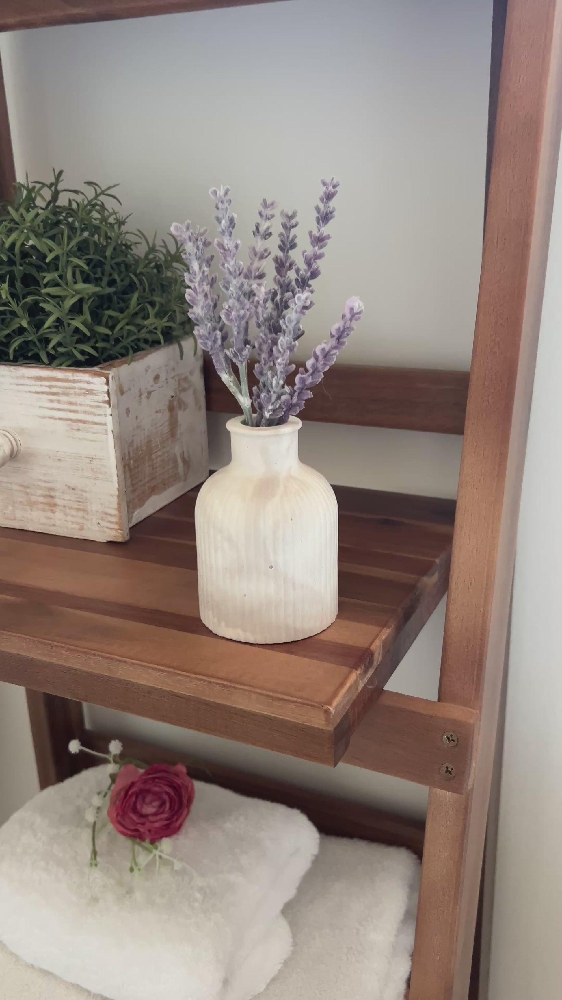 Video showing the Limestone budvase on a wooden shelf in a bathroom setting. 