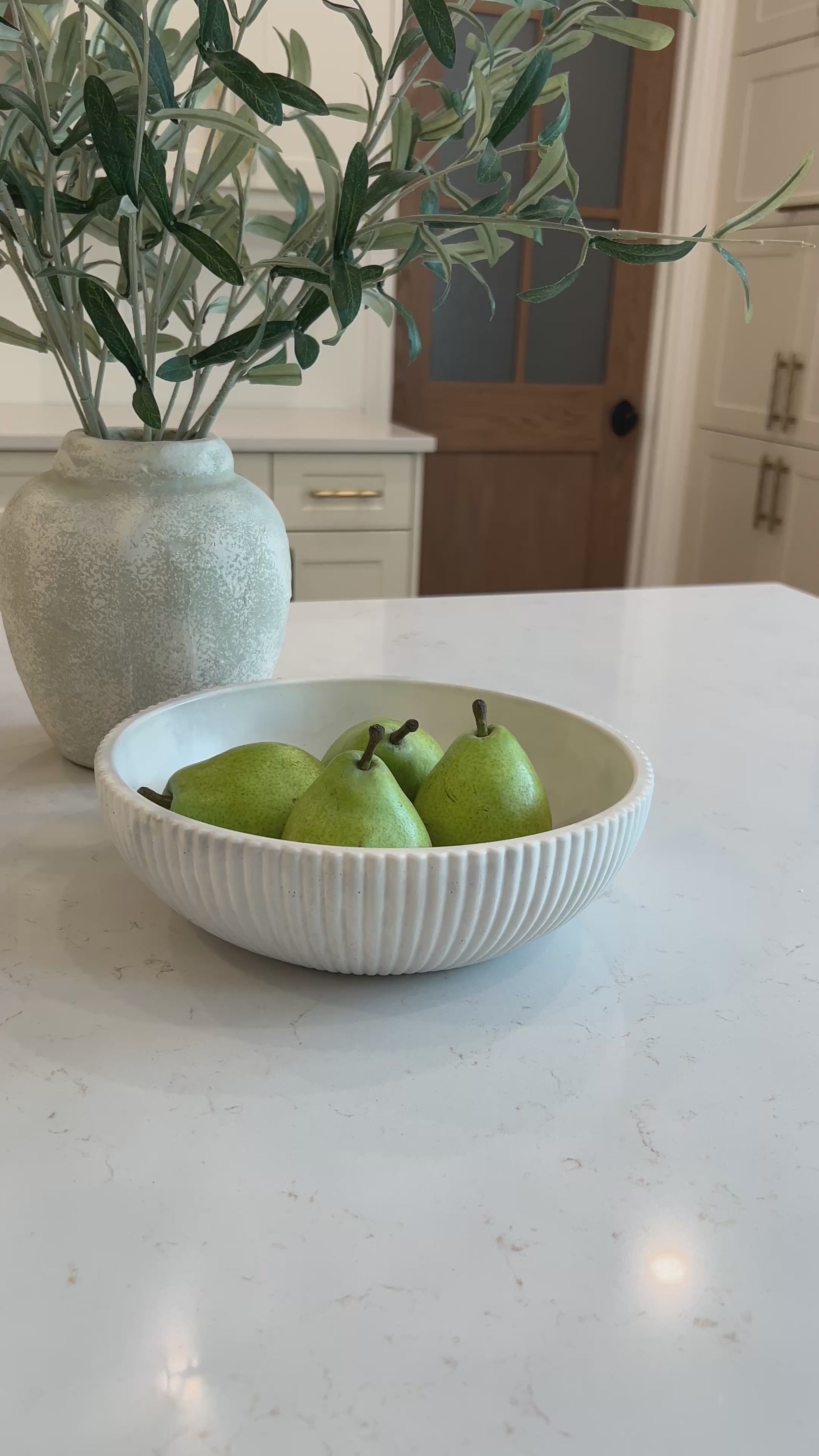video of our limestone bowl in the kitchen with three pears in it 