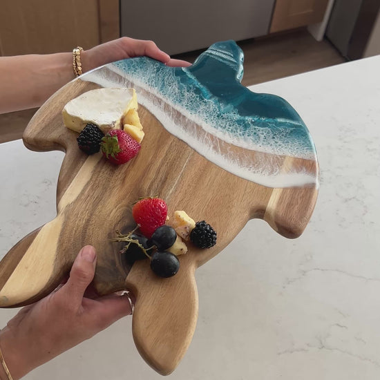video of a women holding the ocean vibes turtle board 