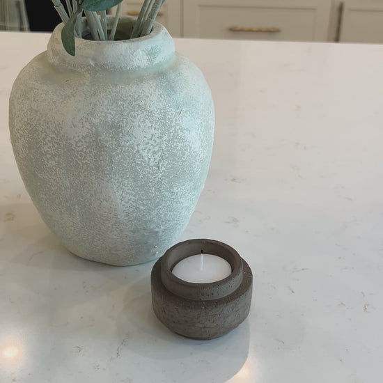 Video of the mocha candle holder on a kitchen countertop displayed beside an olive branch 