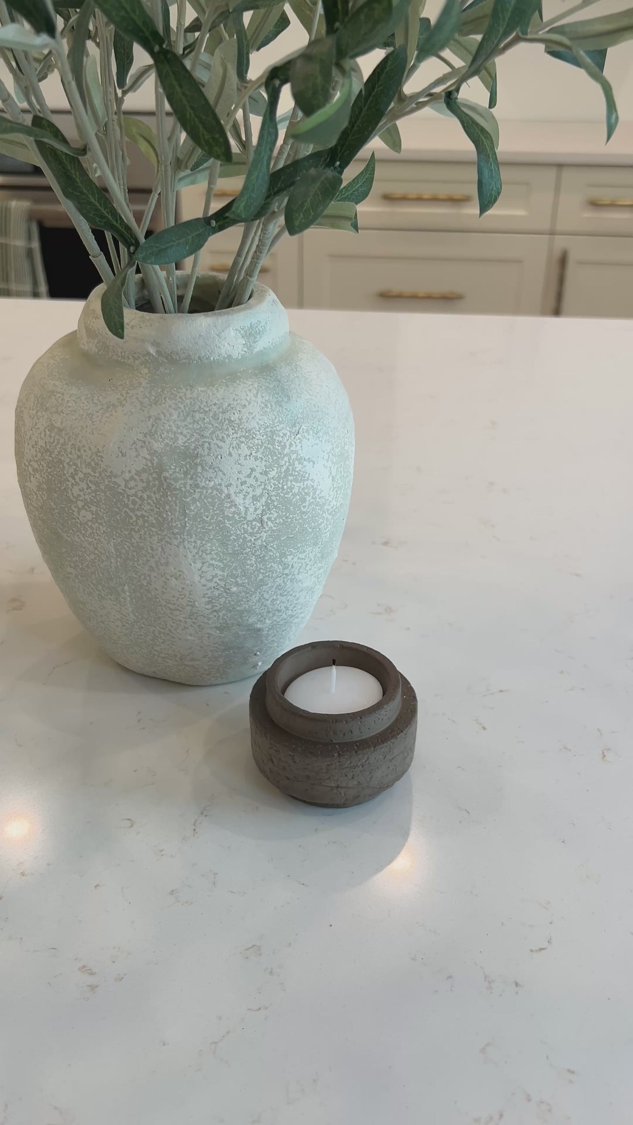 Video of the mocha candle holder on a kitchen countertop displayed beside an olive branch 