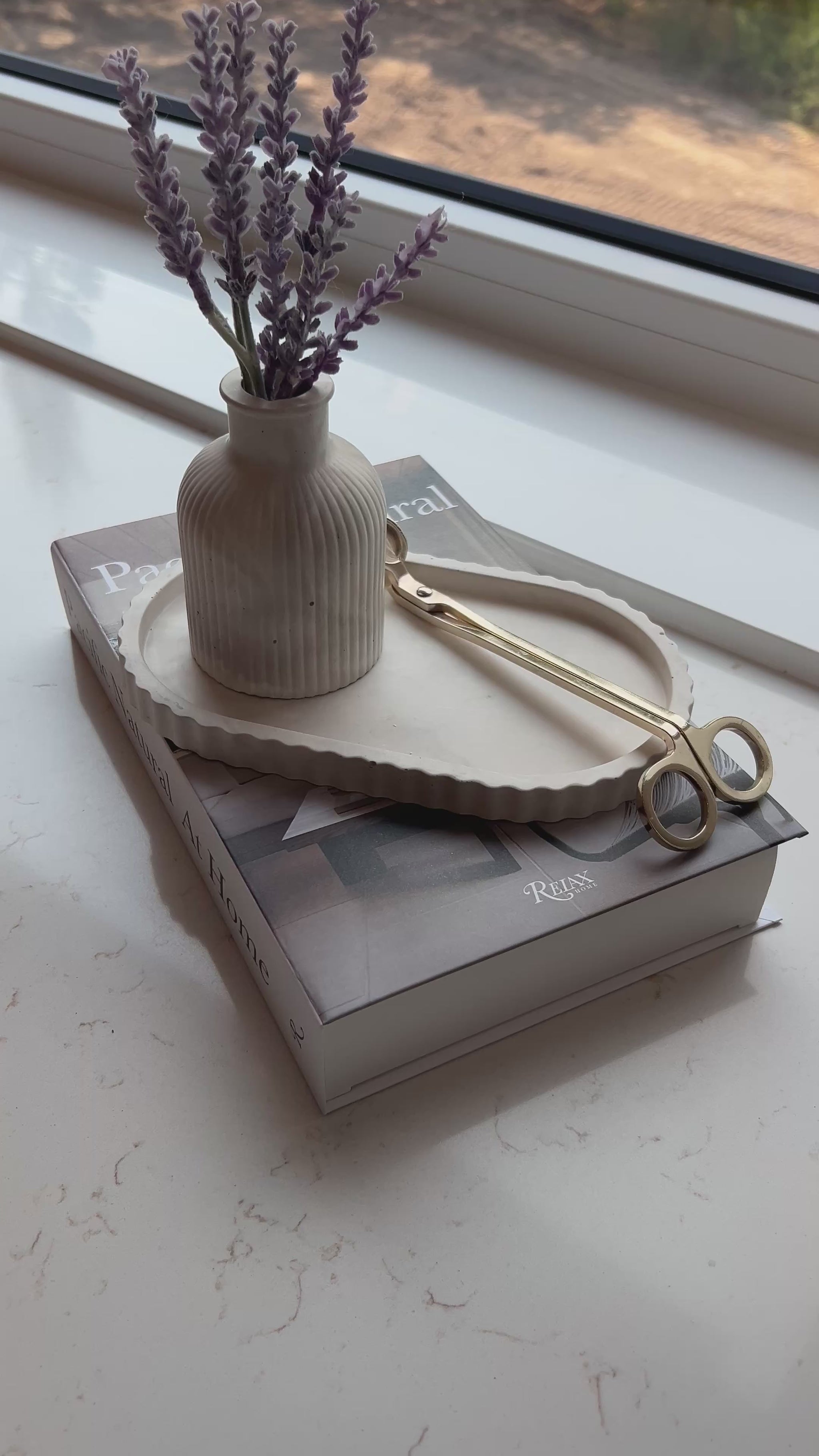 video of our limestone oval tray and bud vase on a stack of books 