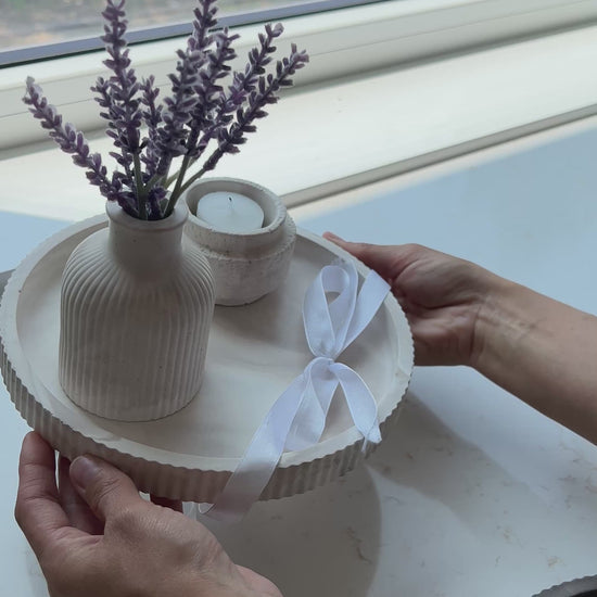 women holding a gift set of our round limestone tray with budvase and candle holder on top of it 