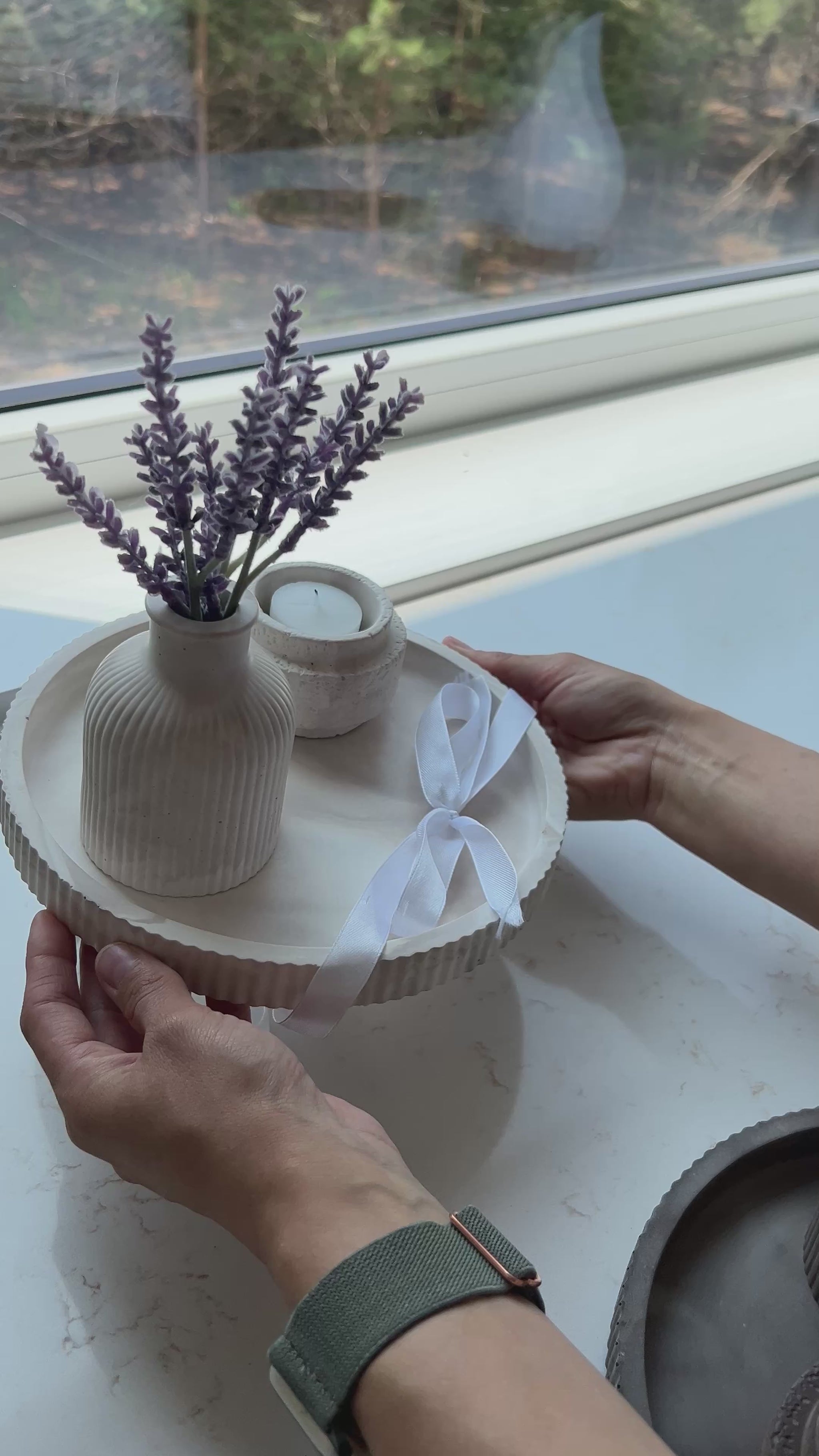 women holding a gift set of our round limestone tray with budvase and candle holder on top of it 